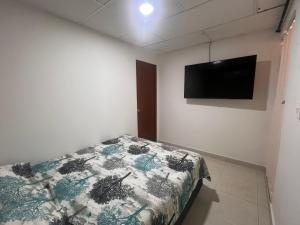 a bedroom with a bed and a flat screen tv at Aparta estudio Santa Marta in Santa Marta