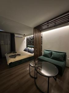 Къща за гости Рилски чардак في ساباريفا بانيا: غرفة نوم بها سرير وأريكة وطاولة