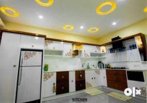 a kitchen with white cabinets and yellow ceilings at Charis Villa and Guest house 5bed 4bath in kunnamkulam in Kunnamkulam