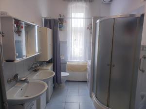 un bagno con due lavandini, una doccia e un WC di Retro Apartment 120 m2 a Szczawno-Zdrój