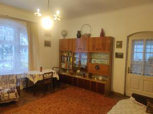 un soggiorno con un tavolo e una libreria di Retro Apartment 120 m2 a Szczawno-Zdrój