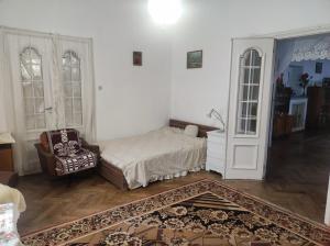 una camera da letto con un letto e una sedia in una stanza di Retro Apartment 120 m2 a Szczawno-Zdrój