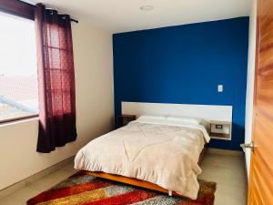 a bedroom with a blue wall and a bed at Suite in Ibarra