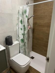a bathroom with a toilet and a shower curtain at Apartamento Playa en Manilva in San Luis de Sabinillas