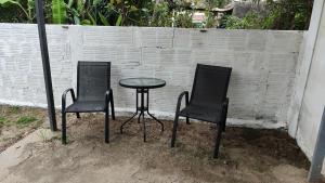due sedie e un tavolo di fronte a un muro di mattoni di Ruma a Bella Unión