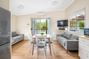 uma sala de estar com uma mesa e um sofá em Koala Shores Holiday Park em Lemon Tree Passage
