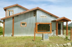 a metal building with a sign in front of it at Guanaco Inn in El Calafate