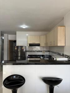 a kitchen with white cabinets and black counter tops at La Morada del Sur in Floridablanca +6 photos