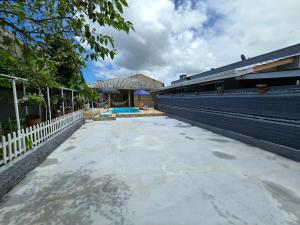 a swimming pool sitting next to a white fence at Casa das Flores com piscina in Matinhos