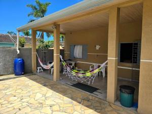 a patio with two hammocks and a house at Casa das Flores com piscina in Matinhos +20 photos