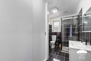 a bathroom with a sink and a toilet at Wyrallah House - Stay 5 Nights PAY 4 - Jan 1-22 in Lakes Entrance +11 photos