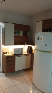 una cucina con frigorifero bianco e forno a microonde di Apto - Relax aqui é Praia a Bertioga