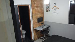una stanza con un bagno e una scrivania con un computer di Apto - Relax aqui é Praia a Bertioga