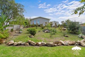 a yard with rocks in front of a house at Wyrallah House - Stay 5 Nights PAY 4 - Jan 1-22 in Lakes Entrance