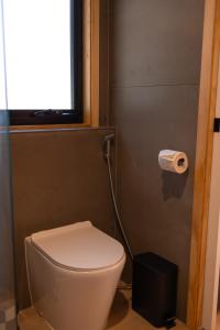 a bathroom with a toilet and a roll of toilet paper at Whittle Home - NEW TINY HOME in Robe