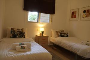 een slaapkamer met twee bedden en een raam bij May O'Dea Suite in Orihuela-Costa