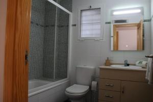 een badkamer met een toilet, een wastafel en een spiegel bij May O'Dea Suite in Orihuela-Costa +16 foto's
