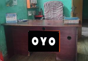 OYO 72817 Palace Inn في Jādabpur: مكتب خشبي عليه علامة oo