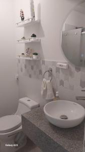 a bathroom with a sink and a toilet and a mirror at Moderno departamento con vista panorámica cerca a los centros comerciales in Lima