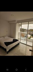 um quarto com uma cama e uma janela grande em Apartamento amoblado Doradal 302 em Doradal