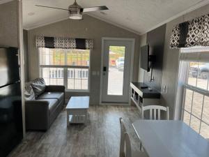 een woonkamer met een bank en een tafel bij Serene Tiny Home - Biker-Friendly, Close to Skyway in Tellico Plains +18 foto's