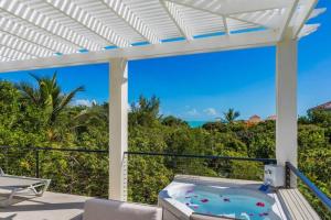 an outdoor patio with a hot tub and a pergola at Wyakha Duplex 1 & 2 in Long Bay Hills