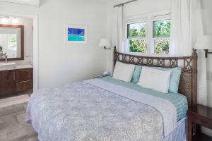 a bedroom with a large bed and a sink at Chuchubi Cottage in Long Bay Hills