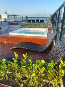 Una terraza con una piscina pequeña y sillas en un balcón. en Melhores Flats - Único, pertinho do mar, en João Pessoa