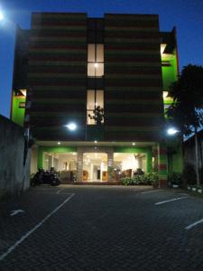 a building with a parking lot in front of it at night at Hotel Caravan in Jakarta