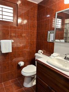 Un baño con inodoro, lavabo y espejo. en Laguna Eco Village #205 Pool/ Tennis Courts/ BBQ, en Quepos 24 fotos más