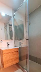 a glass shower in a bathroom with a sink at Posada Pa'sumerce in Tibasosa