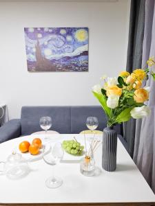 Una mesa blanca con un jarrón de flores y copas de vino. en 금천구 디지털단지 빌라, en Seúl