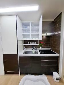 Una cocina con gabinetes blancos y un fregadero. en 금천구 디지털단지 빌라, en Seúl