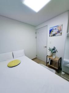 Un dormitorio con una cama blanca grande y una mesa en 금천구 디지털단지 빌라, en Seúl