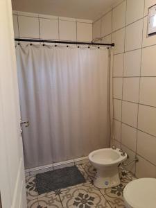 a bathroom with a shower curtain and a toilet at Alamos in Puerto Madryn