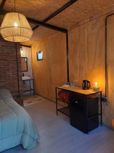 a bedroom with a bed and a table with a kettle on it at Alamos in Puerto Madryn