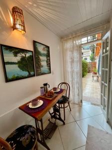 弗洛里亚努元帅镇Cantinho Ítalo-Germânico Hospedagem - Suíte Lavanda - Centro, Marechal Floriano-ES的一间带桌椅和门的用餐室