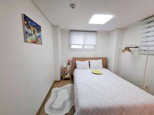 Un dormitorio con una cama blanca con un círculo amarillo encima. en 금천구 디지털단지 빌라, en Seúl