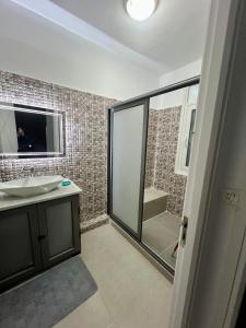 a bathroom with a sink and a shower at Coquette-Appart in Ez Zahra +5 photos
