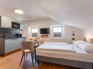 Un dormitorio con una gran cama blanca y una cocina. en Leni Top 4, en Dienten am Hochkönig