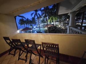 un gruppo di sedie su un balcone con vista sull'oceano di Apartemen marbella anyer tower Nakula lt 2 view kolam renang & laut a Babagan