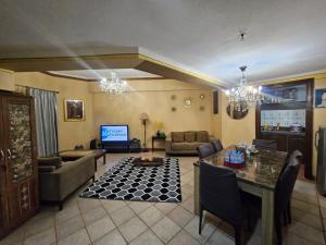 un soggiorno con un divano, un tavolo e delle sedie di Apartemen marbella anyer tower Nakula lt 2 view kolam renang & laut a Babagan