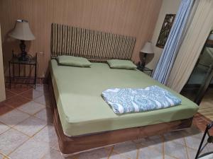 una camera da letto con un grande letto con materasso verde di Apartemen marbella anyer tower Nakula lt 2 view kolam renang & laut a Babagan Altre 10 foto