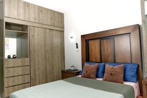 a bedroom with a large bed with a wooden headboard at Casa Los Tules No 10 in Ciudad Guzmán