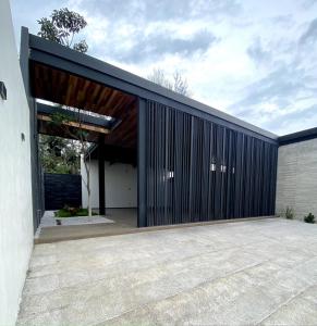 a house with a black facade with a garage at Casa Los Tules No 10 in Ciudad Guzmán