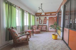 a living room with chairs and a table and windows at Posada D`Lua in Villa Carlos Paz