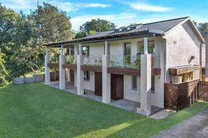 a house with a deck and a lawn at Surfbreak, Culburra Beach in Culburra Beach