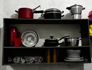 a shelf with pots and pans and other kitchen items at Casa Brisa do Mar in Tamandaré