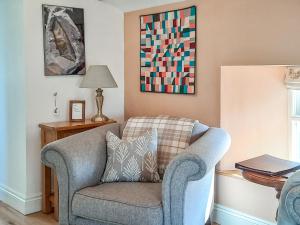 The Hayloft - Uk37563 في Crosby Garrett: غرفة معيشة فيها كرسي ومصباح