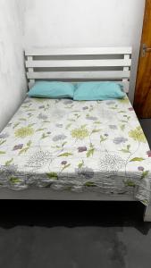 a bed with a white comforter with flowers on it at Casa Brisa do Mar in Tamandaré
